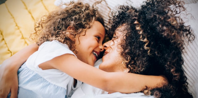 Smiling mom and daughter cuddling